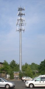 Picture of cell tower monopole in parking lot. Cell tower lease rates, need help call Tower Genius 888-313-9750.